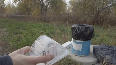 Close-up of female hand throws plastic into the bin outdoor. High resolution. Sl Видео 119309048