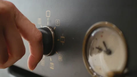 Close-up of a female hand turning the handle of an electric or gas stove Stock Footage 113848737
