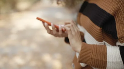 Close up of female hand using cell phone, outdoors. 動画素材 104148954