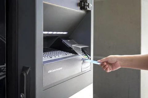 Close up female hand Using Credit Card bank of ATM machine to withdraw money Stock Photos