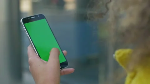Close-up of female hand using a phone with green screen outside Stock Footage 133143735