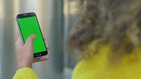 Close-up of female hand using a phone with green screen outside 스톡 동영상 133144556