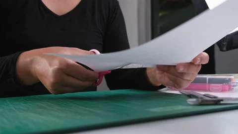 Close-up of female hand using stainless steel scissors to cut paper. Office work Stock Footage 237502709