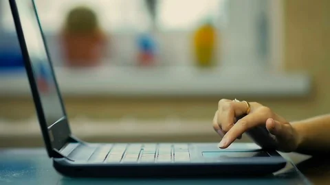 Close-Up a Female Hand Using Touchpad on the Laptop Sitting at the Table at Home Video stock 82355557