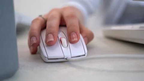 Close up of female hand using a white computer mouse on a light office desk Stock Footage 334733441