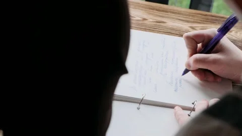 Close-up female hand writes in a notebook Stock Footage 172044256