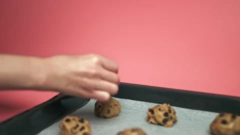 Close-up Female hands adding Chocolate Chips on top of Chocolate Chip Cookies. Stock Footage 135702487
