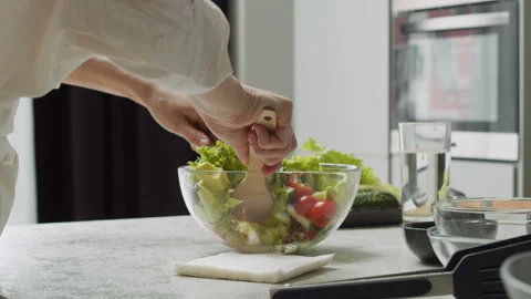 Close-up of female hands adding various seeds to a delicious avocado salad. Stock Footage 260959186