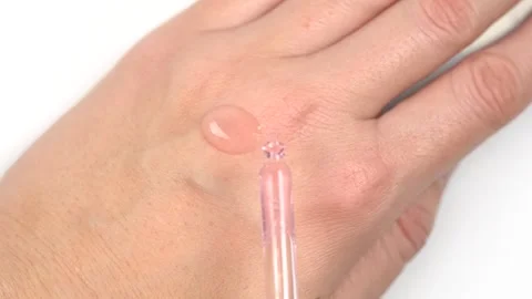 Close up female hands applying clear pink essence or gel drops from the pip.. Stock Footage 294171753