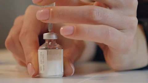 Close-up of female hands are taking a vaccine into a syringe with a needle Stock Footage 168260224