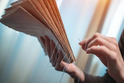 Close up of female hands binding book at home or DIY make book with old paper Stock Photos