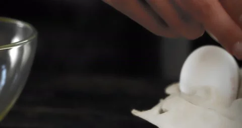 Close-up. Female hands break an egg into a transparent bowl Stock Footage 183404181