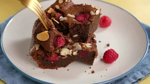 Close-up of female hands break off a piece of chocolate cake with a fork on a Stock Footage 145088937