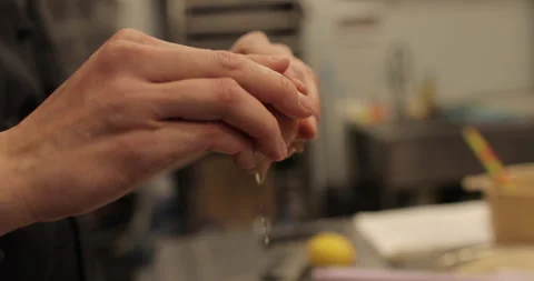 Close-up of female hands breaking an egg and adding Stock Footage 256410072