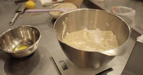 Close-up of female hands breaking an egg and adding Stock Footage 256410142