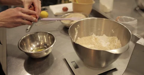 Close-up of female hands breaking an egg and adding Stock Footage 256410431