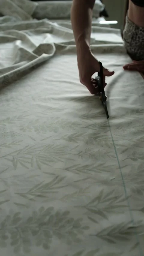 Close up of female hands carefully cuts cotton fabric with scissors Video stock 316920544
