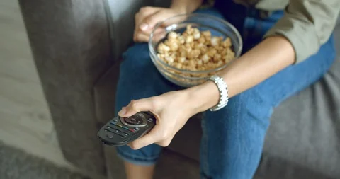 Close up of female hands changing the channels on the TV with the remote control Stock Footage 129381836