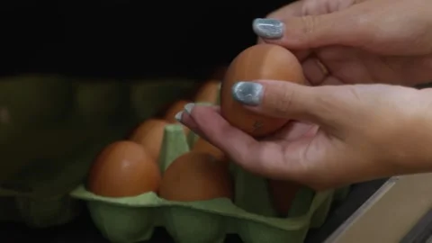 Close up of female hands choosing eggs in a supermarket. Girl holding a package Stock-Footage 280036302