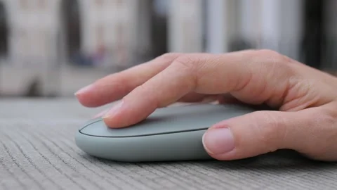 Close-up of female hands click on computer mouse on wooden table. Girl student Stockbeeldmateriaal 220198172