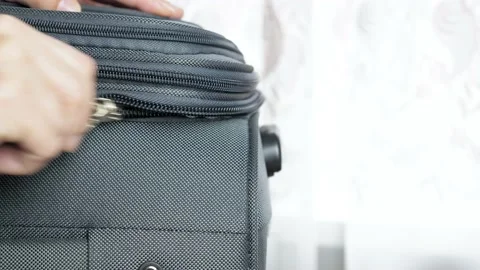 Close-up female hands close the suitcase and fasten it with a lock. The girl Video stock 209643050