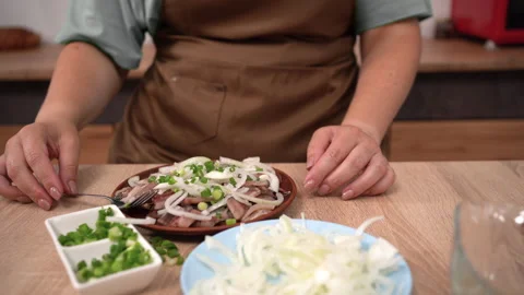 Close-up of female hands of a cook preparing a salad of salted herring with Stock Footage 316975913