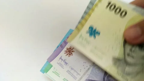 Close-up of female hands counting a stack of Indonesian Rupiah money. Stock Footage 223146504