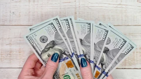 Close-up of female hands counting a stack of hundred-dollar US banknotes. A.. Stock Footage 236324088