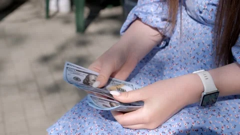 Close-up of female hands counting a stack of hundred dollar US banknotes. a Stock Footage 246861116