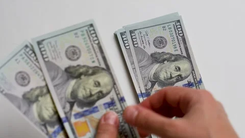 Close-up of female hands counting a stack of hundred dollar Stock Footage 256216010