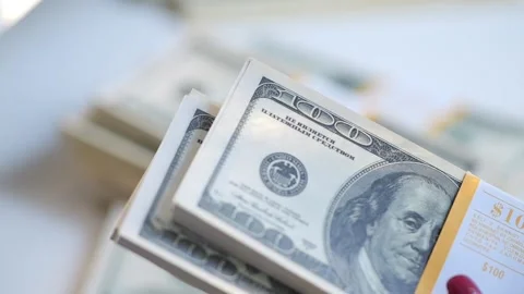 Close-up of female hands counting a stack of hundred-dollar US banknotes. a Stock Footage 266262340