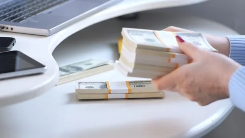 Close-up of female hands counting a stack of hundred-dollar US banknotes. a Stock Footage 266369563