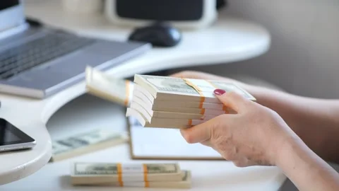 Close-up of female hands counting a stack of hundred-dollar US banknotes. a Stock Footage 267049457