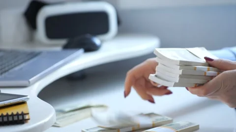 Close-up of female hands counting a stack of hundred-dollar US banknotes. a Stock Footage 267349448