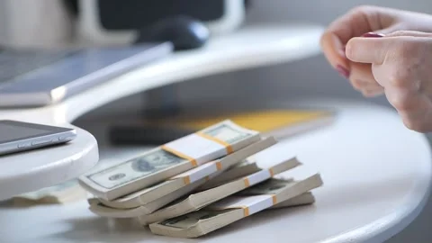 Close-up of female hands counting a stack of hundred-dollar US banknotes. a Stock Footage 268429037
