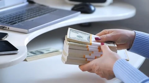 Close-up of female hands counting a stack of hundred-dollar US banknotes. a Stock Footage 270314110