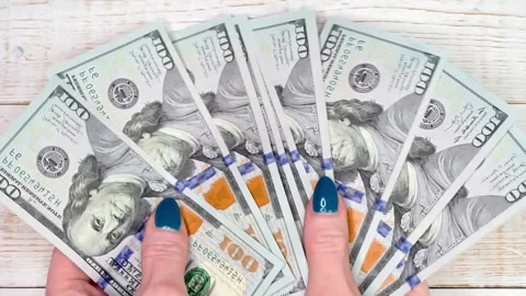 Close-up of female hands counting a stack of hundred-dollar US banknotes. A.. Stock Footage 278528612