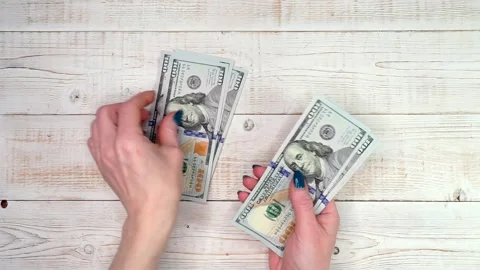 Close-up of female hands counting a stack of hundred-dollar US banknotes. A.. Stock Footage 303931145
