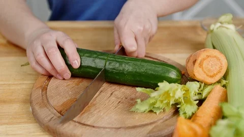 Close female hands cut cucumber at celery and carrot Vidéo 101245587