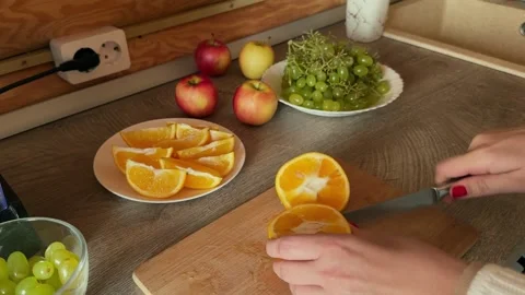 Close-up of female hands cuts oranges for a festive table Stock Footage 293609165