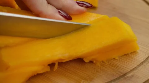 Close-up of the female hands cutting a half of the ripe pumpkin into slices Video stock 232624704