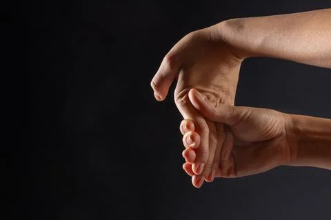 Close up of female hands doing hand stretching on dark background, hand war.. Stock Photos