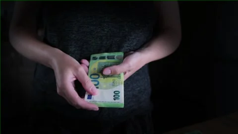 Close-up female hands fold a stack of euro cash bills on a dark background. Stock Footage 244162726
