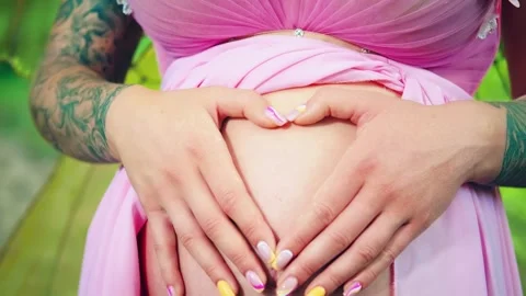 Close-up female hands folded in shape of heart symbol love, pregnant bare belly Stock Footage 308375367