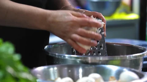 Close-up of female hands grating champignons into bowl on table. Stock Footage 267280758