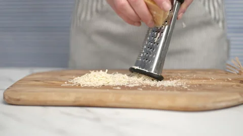 Close-up of female hands grating parmesan cheese. Stock Footage 134687649