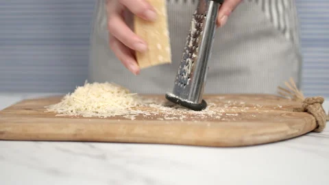 Close-up of female hands grating parmesan cheese. Stock Footage 134688025