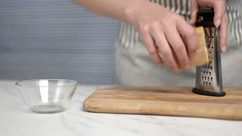 Close-up of female hands grating parmesan cheese. Stock Footage 134691089