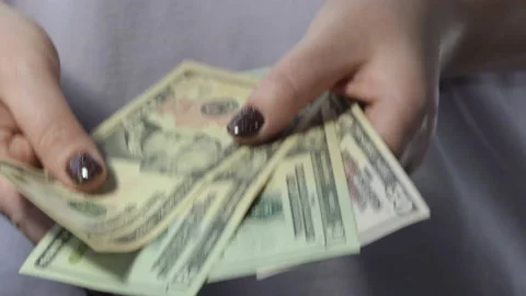 Close-up of female hands of hands counting US dollar bills. girl counts cash Stock Footage 227962390