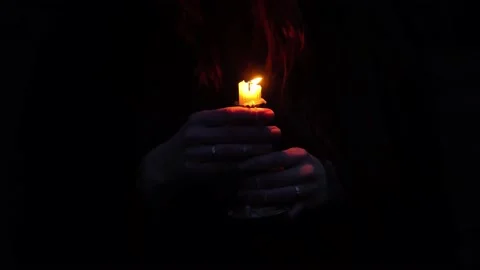 Close-up of female hands holding burning candle with visible hair and dripping w Stock Footage 135533050